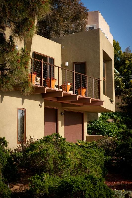 A house featuring a balcony with a decorative railing, showcasing a charming architectural design.