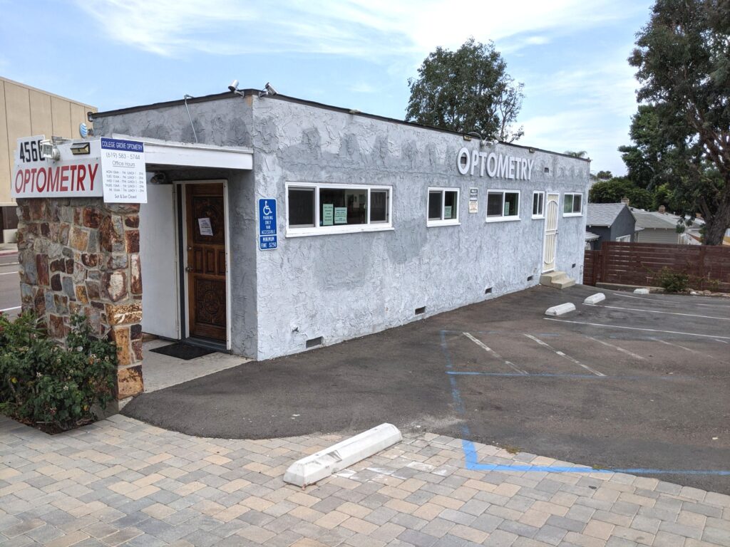 A building with a parking lot in front, featuring a prominent sign displaying the establishment's name.